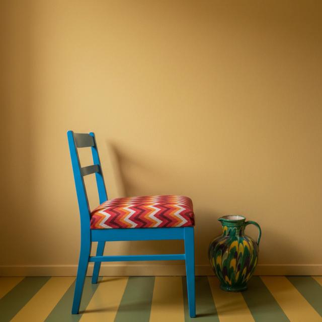 Eclectic living room with a colourful chair and patterned floor