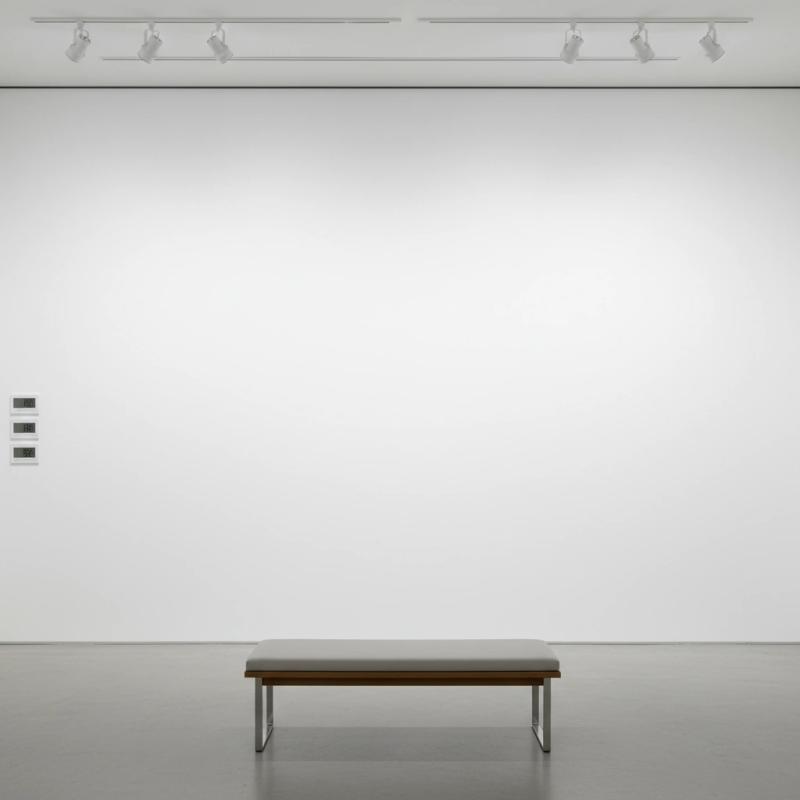 Minimalist gallery with track lighting and a bench