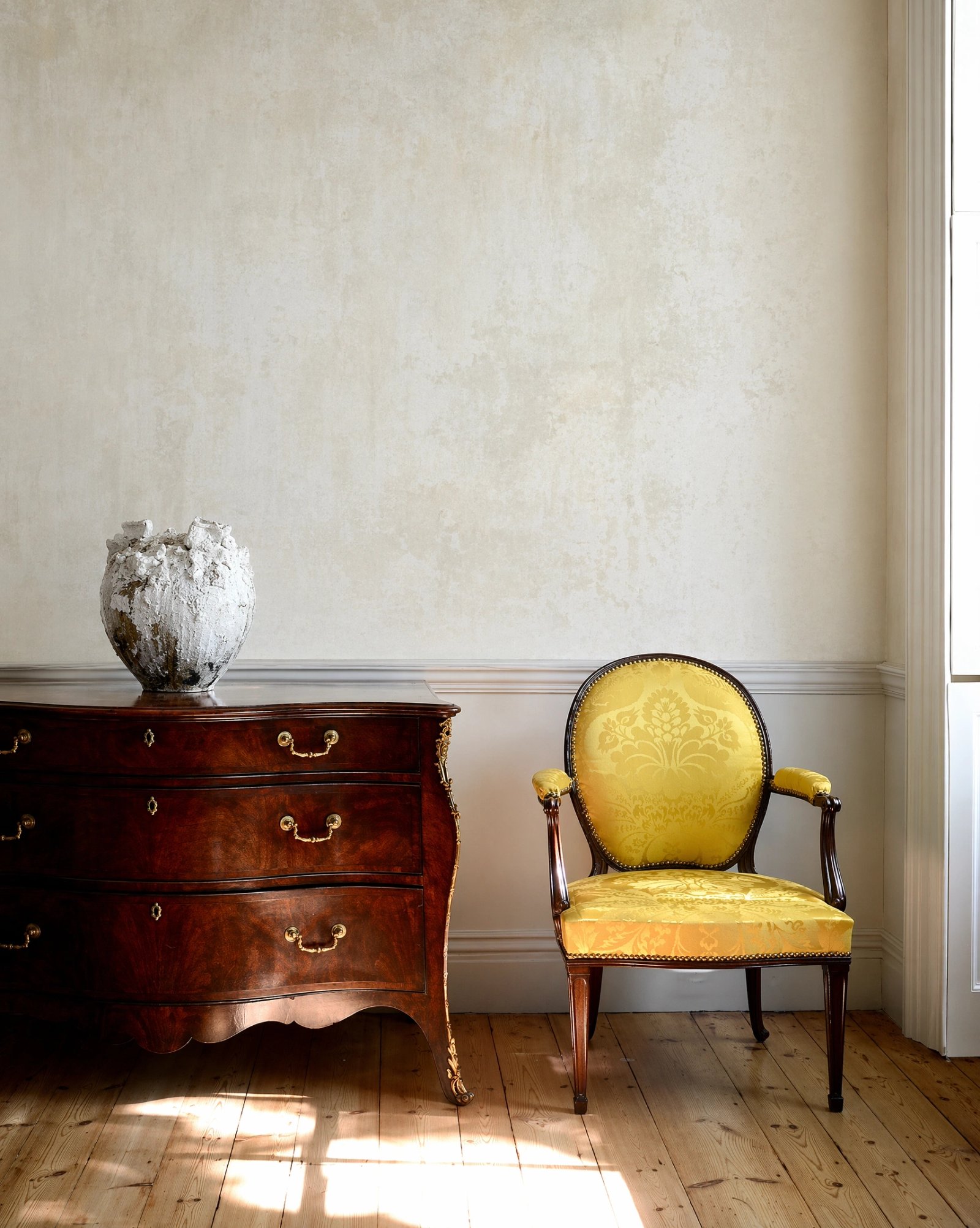 Wall art mockup: Grand room with an antique chest and yellow chair, with a cabinet