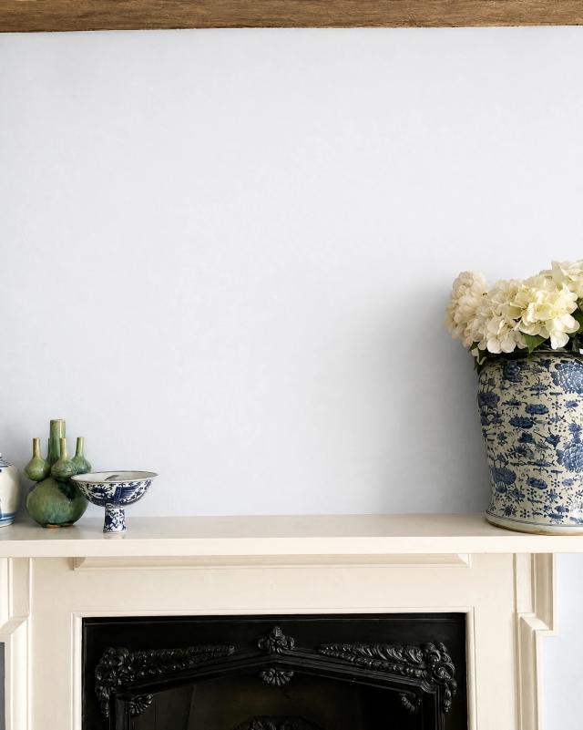 Grand room with a white wall and ornate fireplace