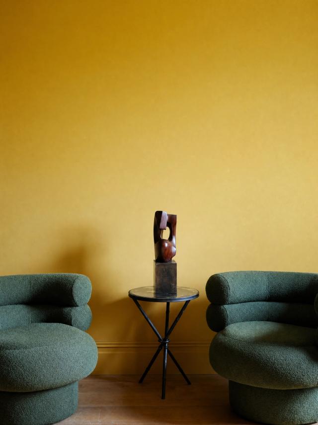 Eclectic living room with yellow walls and armchairs