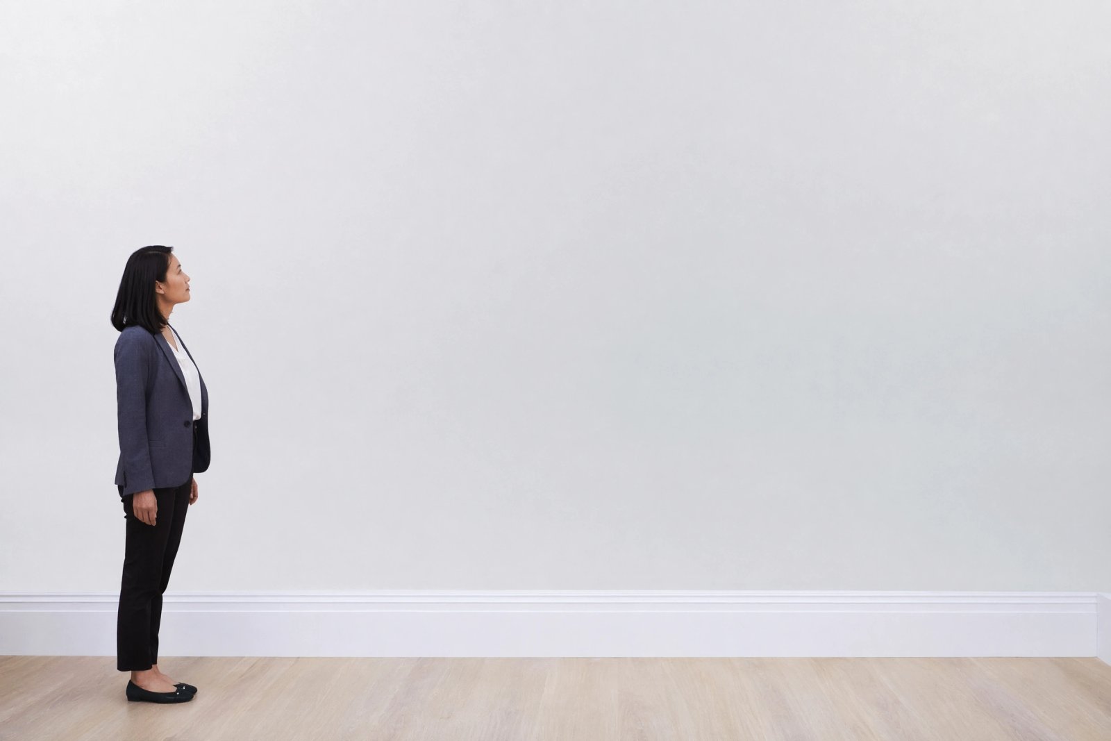 Wall art mockup: White gallery space with a person looking at the wall, with a person