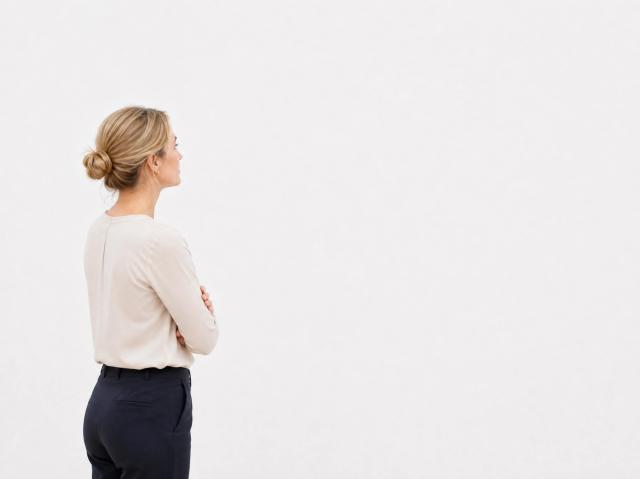 Minimalist white-cube gallery with a visitor looking at the wall