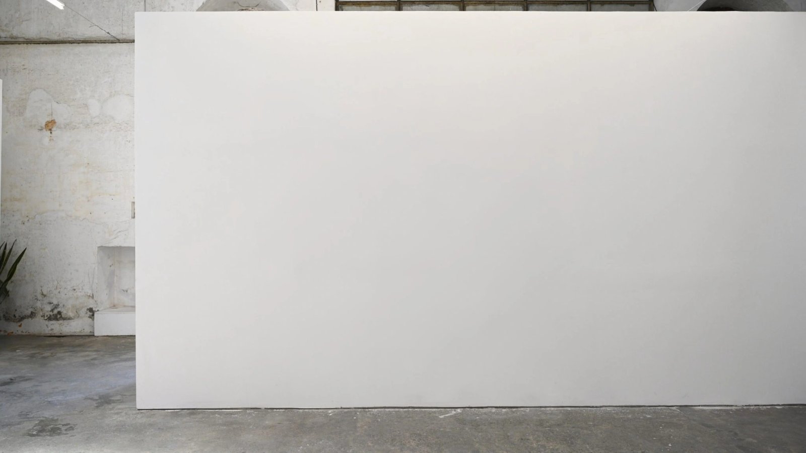 Wall art mockup: Minimalist gallery with a large white display wall