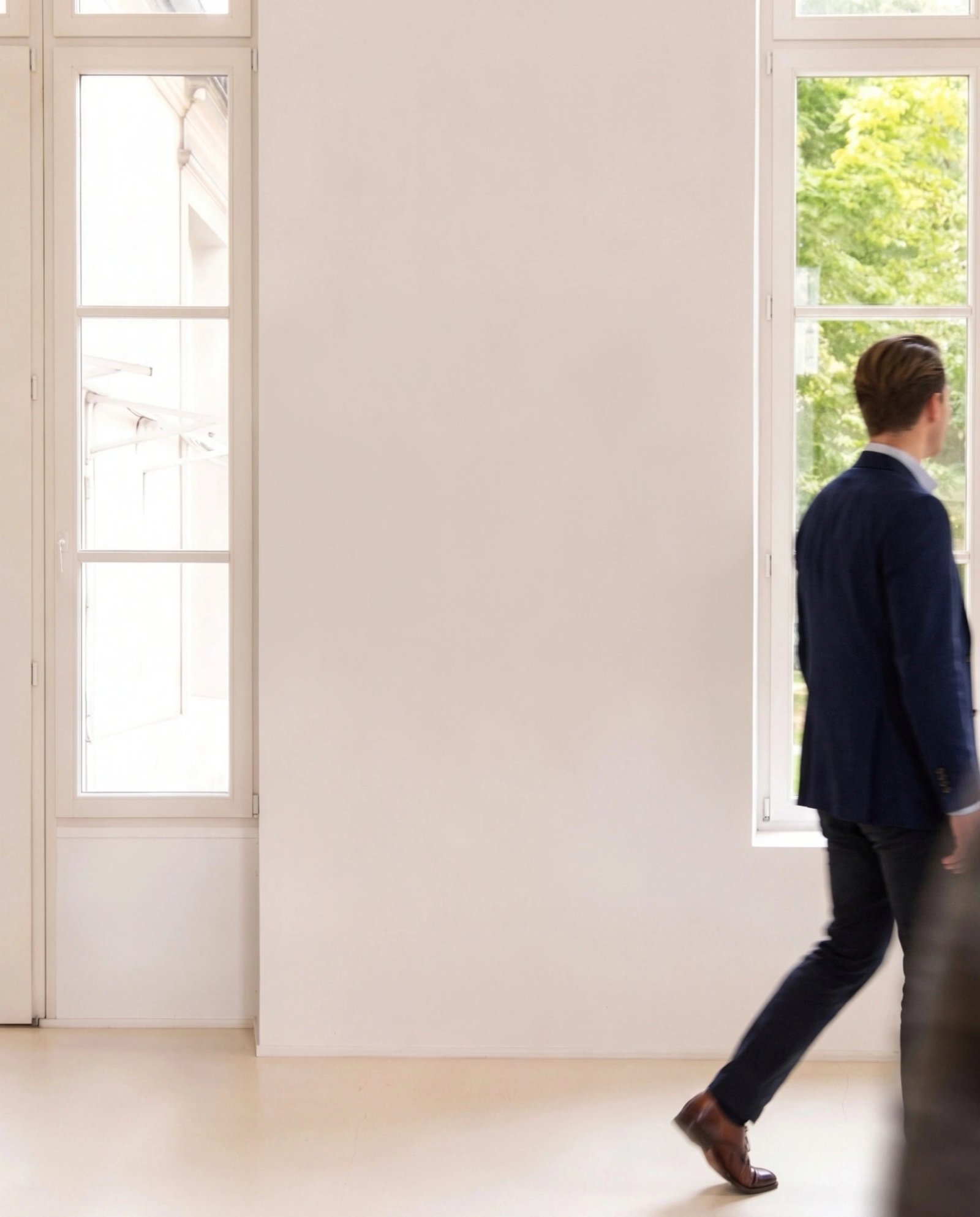Wall art mockup: Bright gallery space with a person walking through, with a person