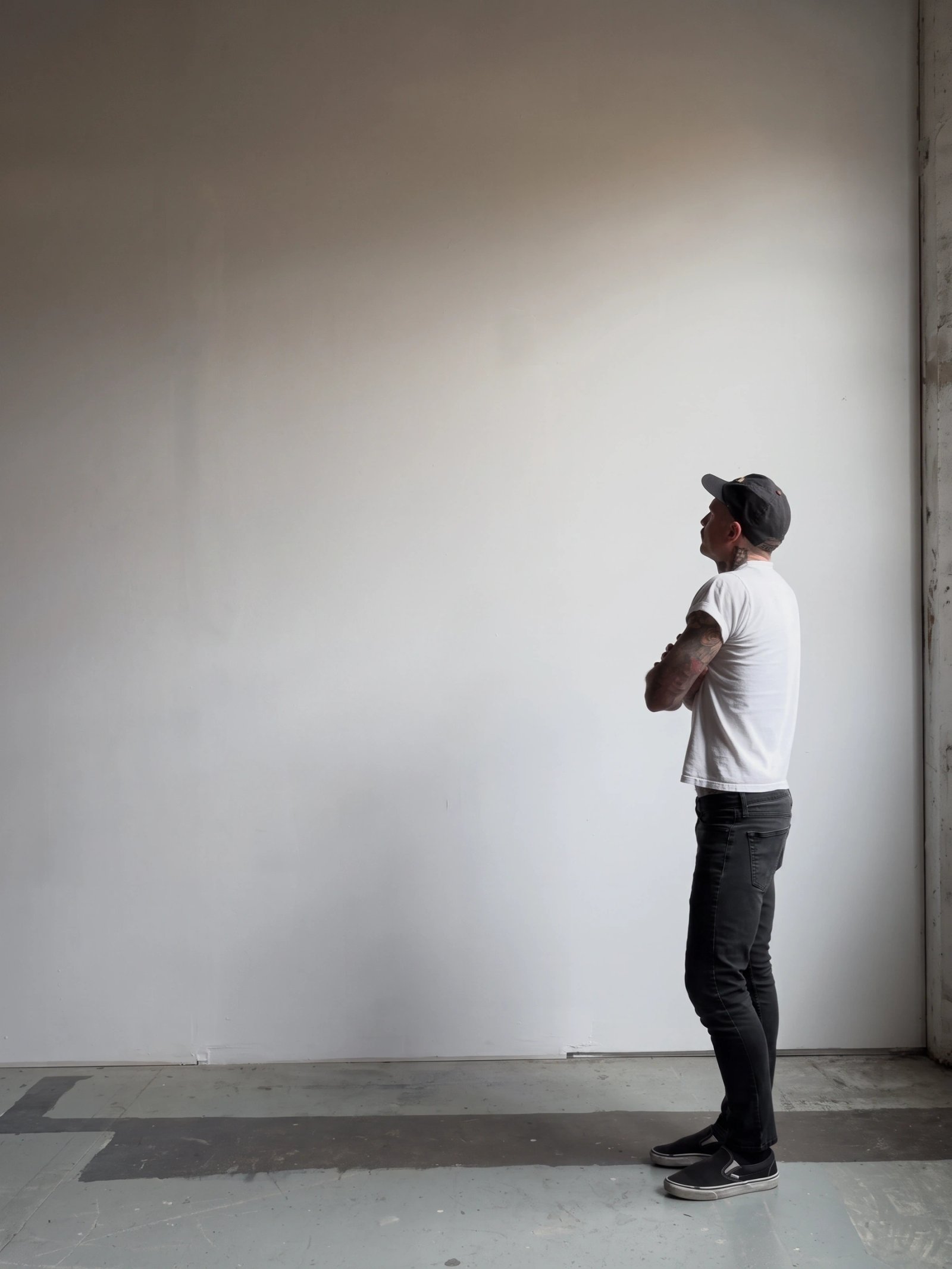 Wall art mockup: Minimalist gallery space with a man looking up, with a person