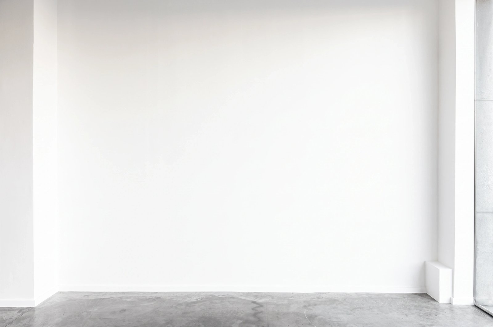 Wall art mockup: Minimalist gallery with white walls and concrete floor