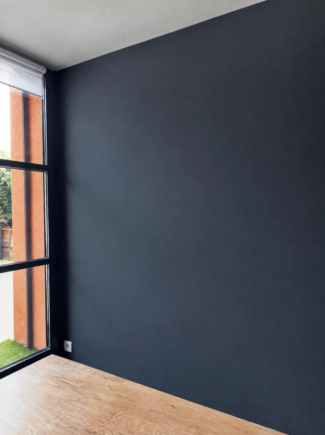 Two sample paintings hung together in Navy wall beside a steel-framed window